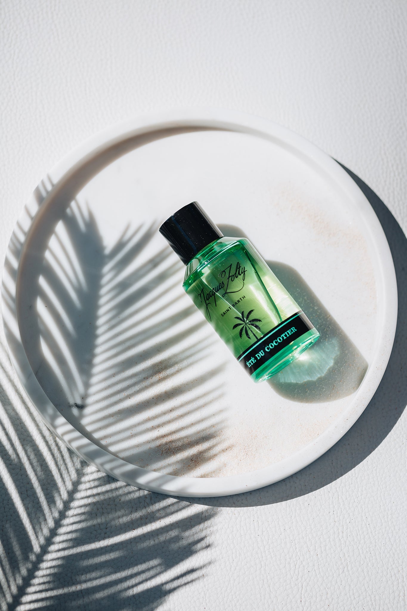 Été du Cocotier green fragrance bottle in soft light