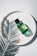 Été du Cocotier green fragrance bottle in soft light