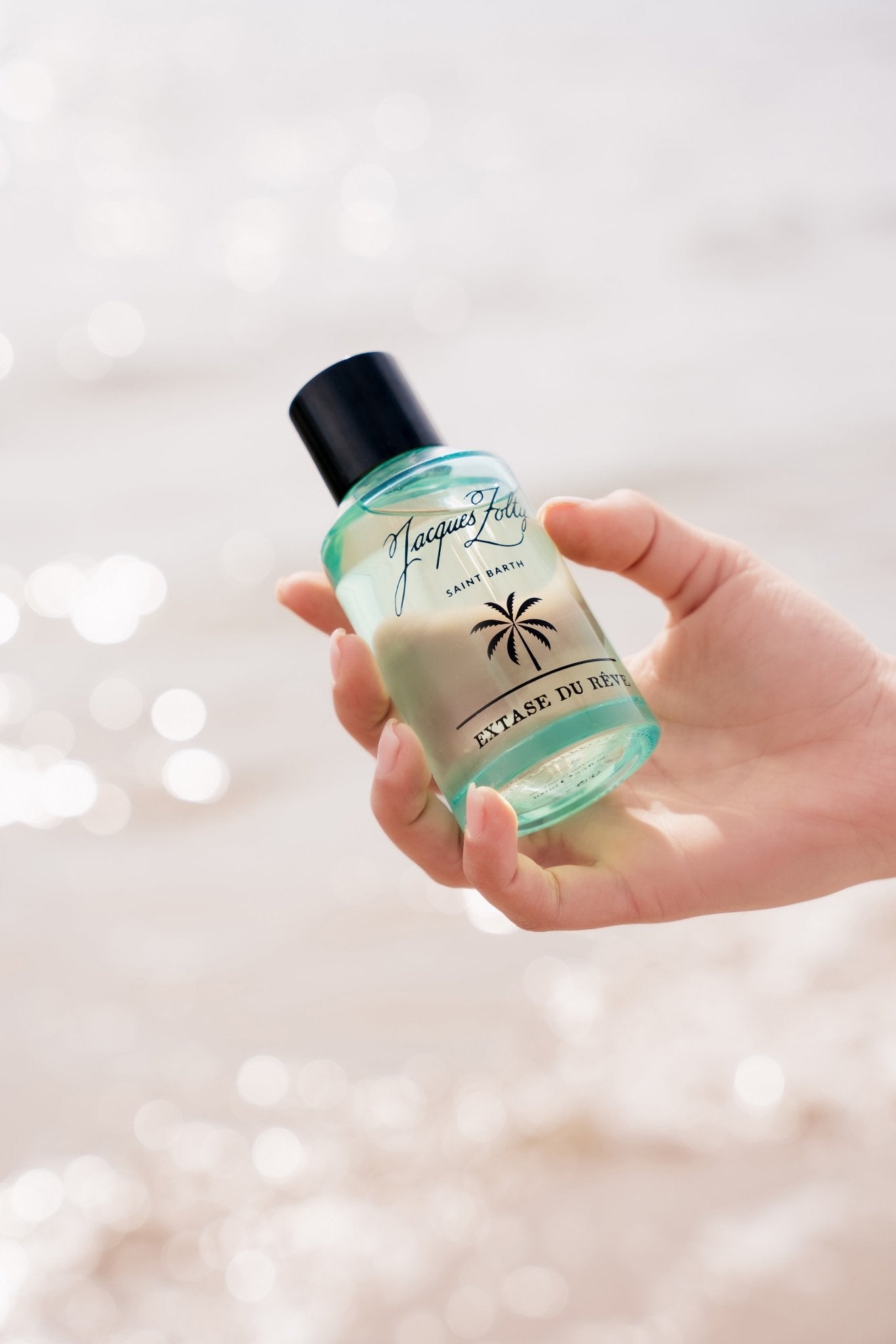 Extase Du Rêve fragrance bottle held to the light