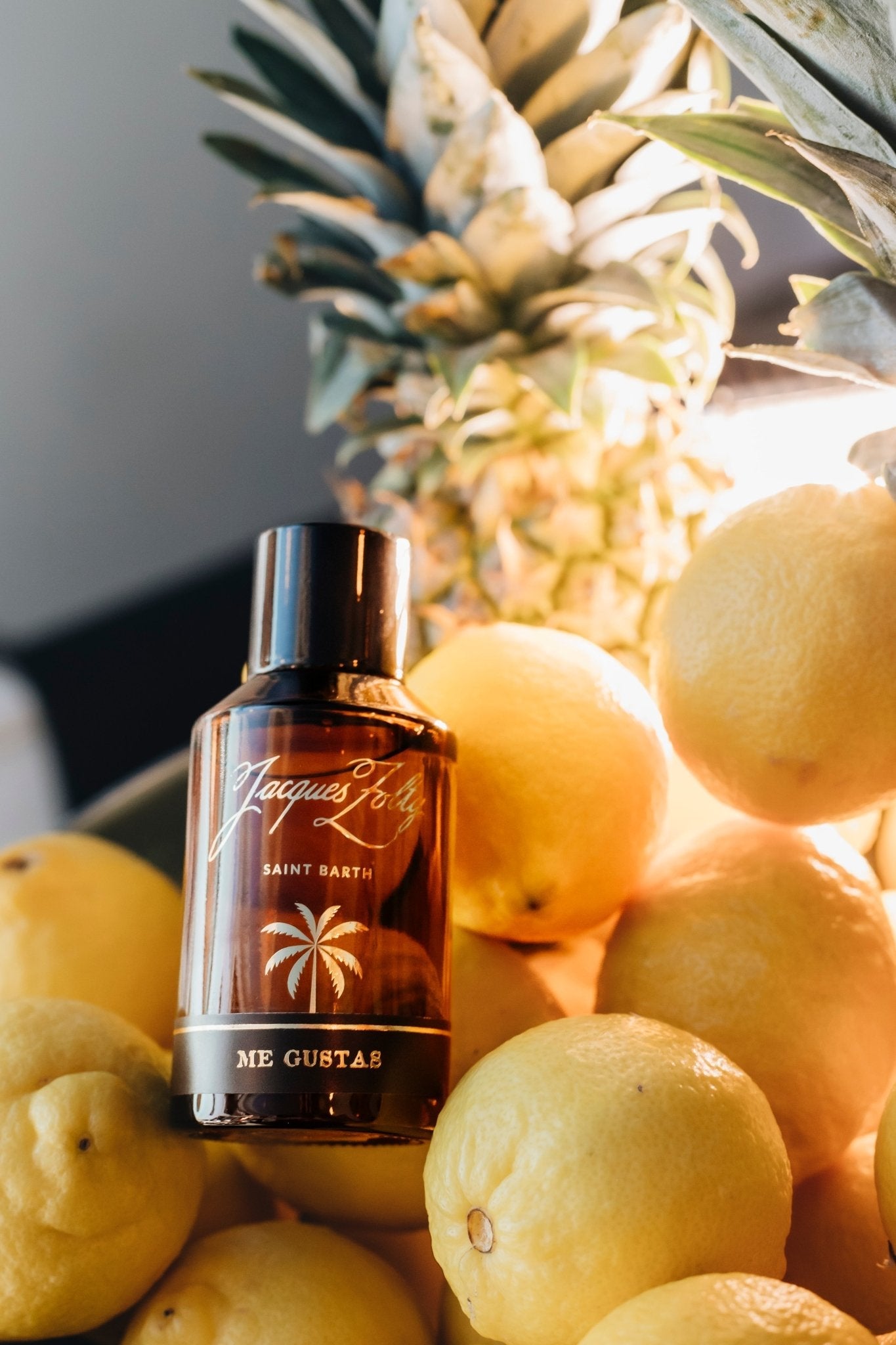 Me Gustas fragrance beside a pineapple in sunlight